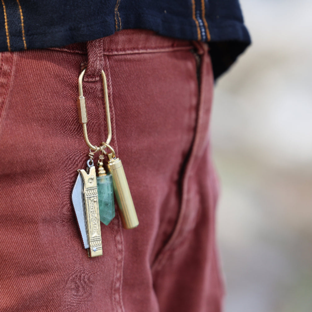 Purse charm with a functional tool, a crystal bottle, and a container clipped on a belt loop