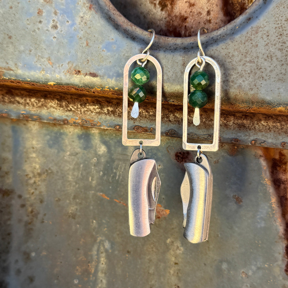 Silver Metal Billie Mini Pocket Knife dangling from rounded top frame with two faceted emerald beads hanging from ear wire