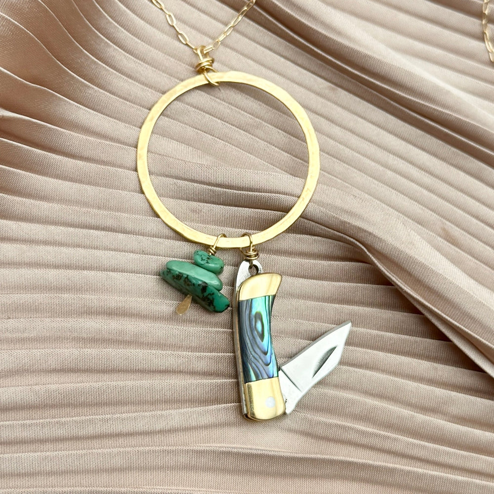 necklace with small abalone inlay pocketknife and two turquoise bead chips hanging from round open circle pendant