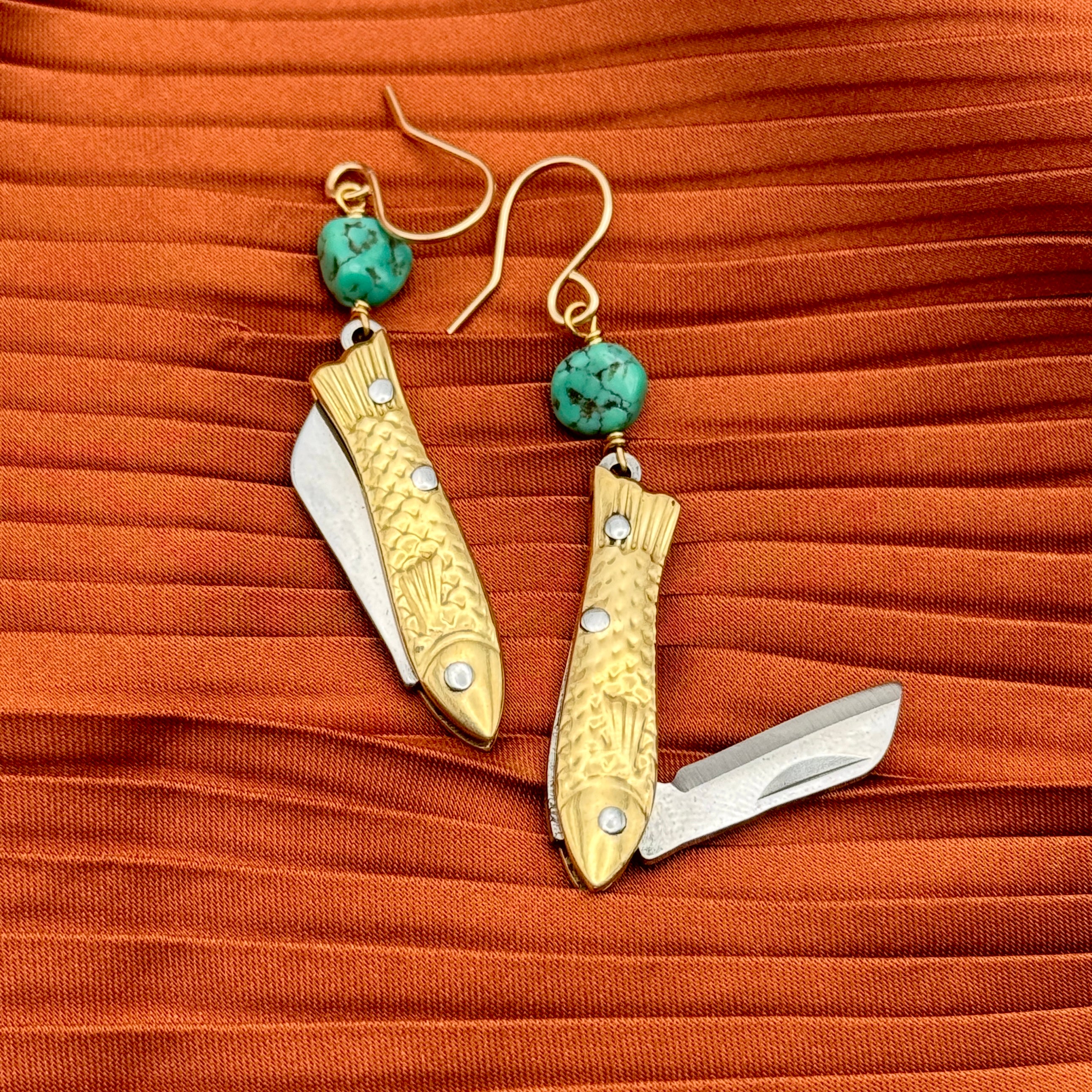A pair of earrings featuring gold-colored miniature fish shaped utility working pocket knife with turquoise nuggets on a sterling silver or 14 karat gold fill ear wire