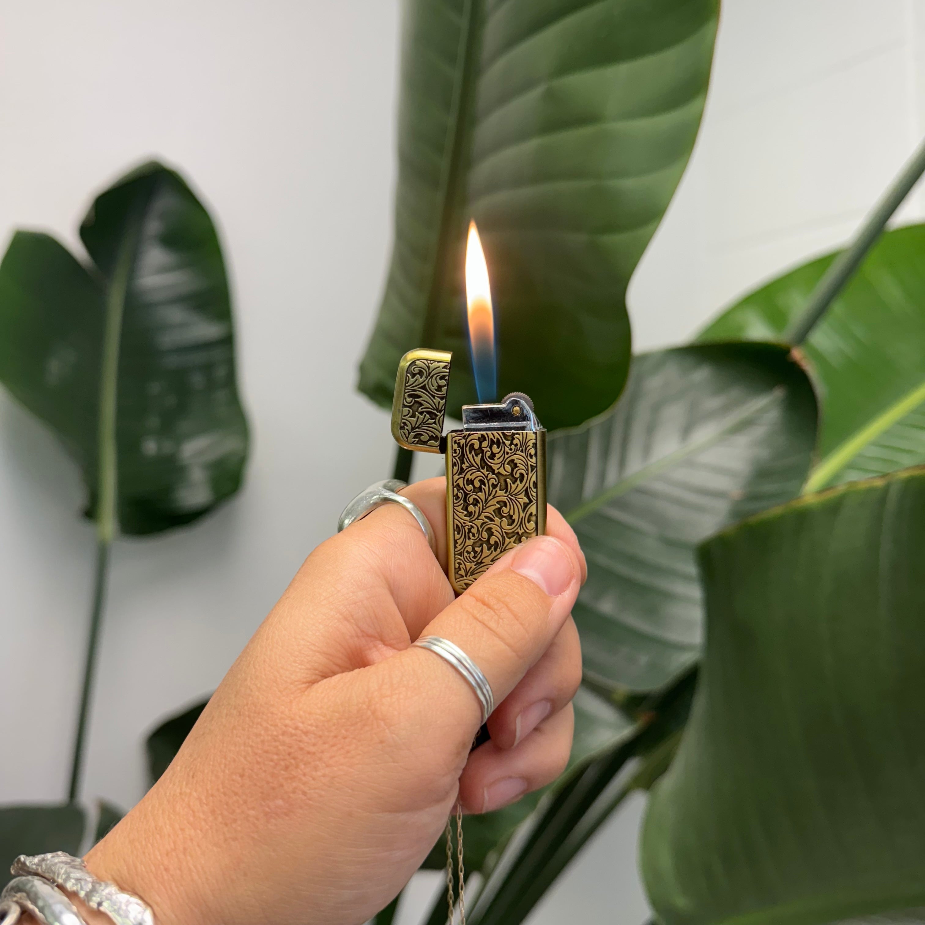 Brass engraved lighter with turquoise stones on a gold necklace chain