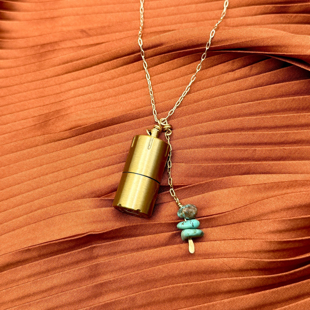 Brass lighter with turquoise stones on a gold necklace chain