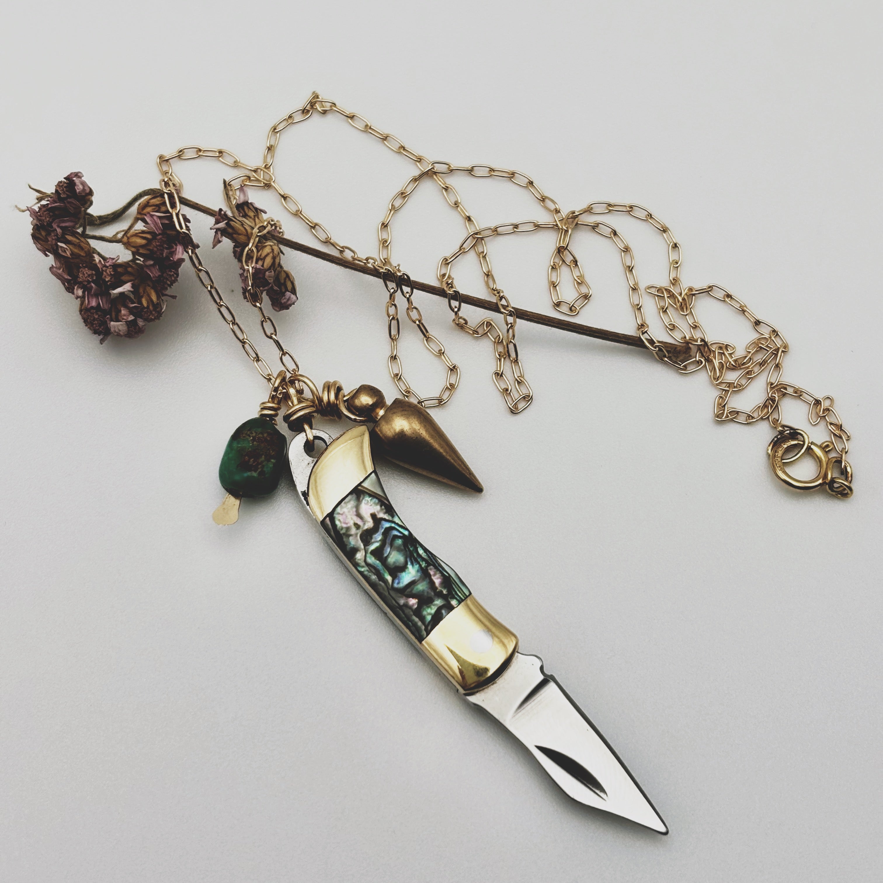 Abalone inlay and gold handle miniature pocketknife hanging with a turquoise stone and mini bullet
