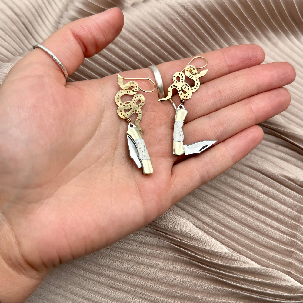 gold snake pendant with bone inlay mini pocketknife hanging from gold ear wire