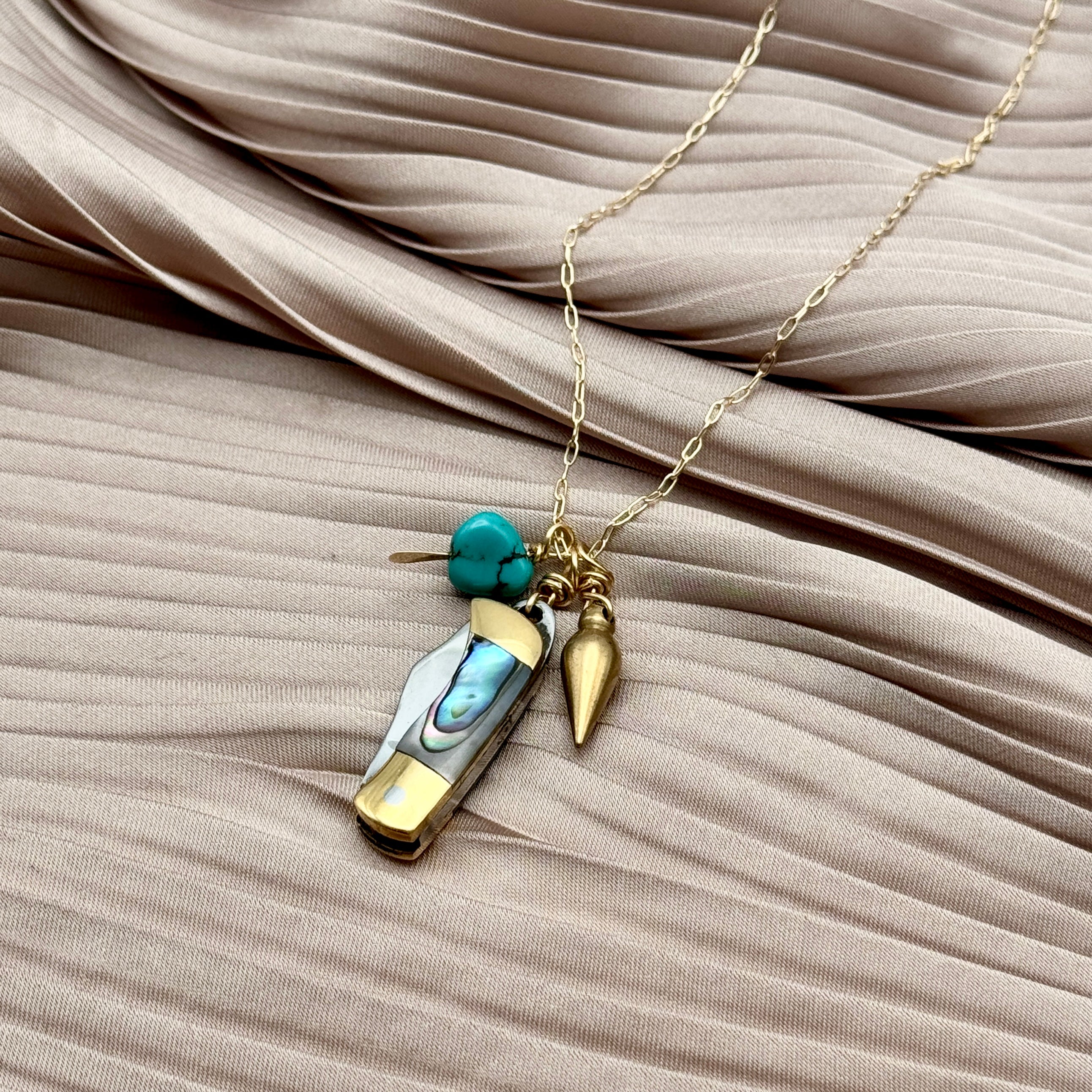 Abalone inlay and gold handle miniature pocketknife hanging with a turquoise stone and mini bullet