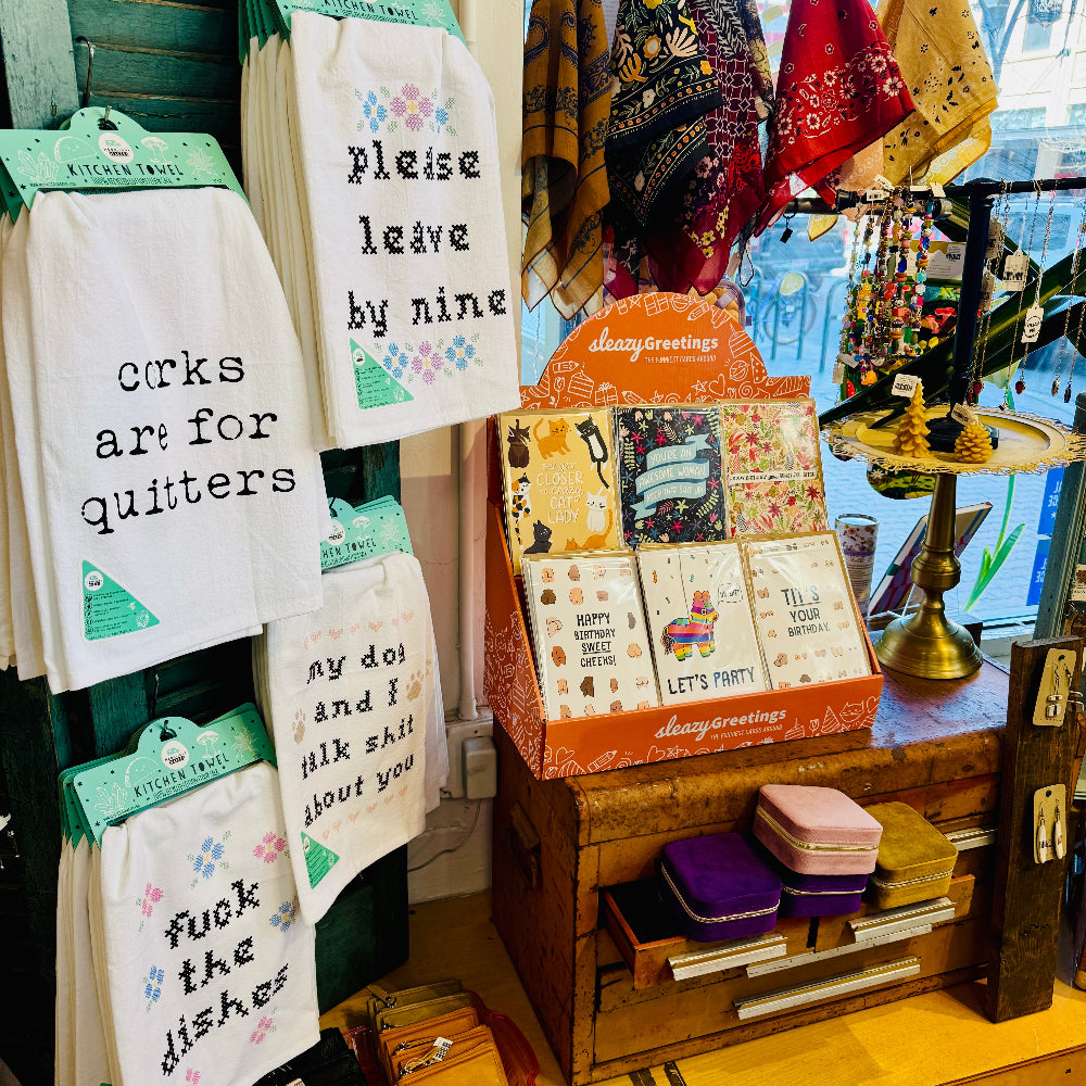 kitchen towels and greeting cards and bandanas on display
