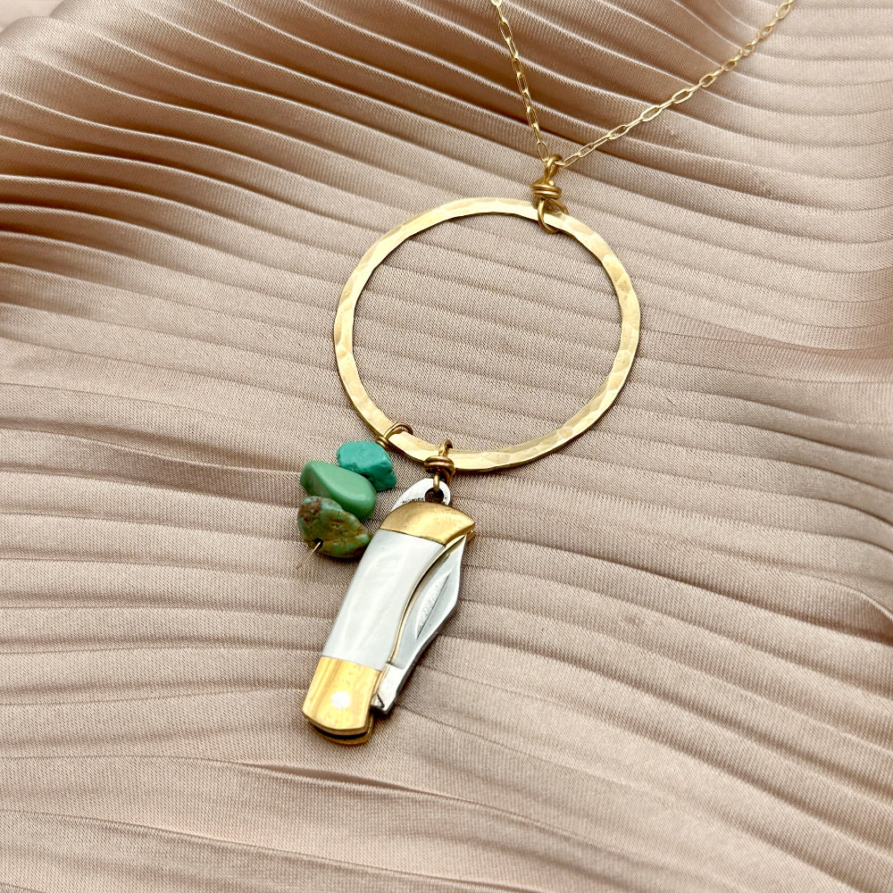 Necklace with small mother of pearl inlay pocketknife and two turquoise bead chips hanging from open circle pendant
