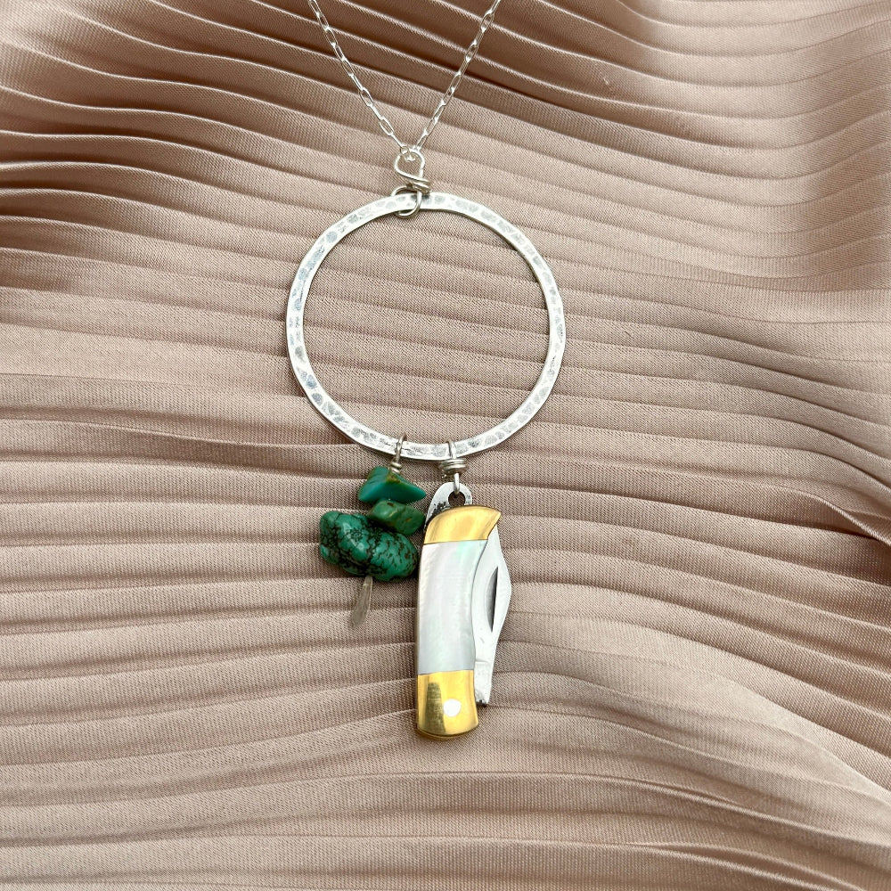 Necklace with small mother of pearl inlay pocketknife and two turquoise bead chips hanging from open circle pendant