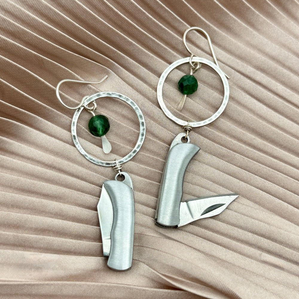 Silver Metal Billie Knives hanging from circle pendant with emerald bead from ear wire