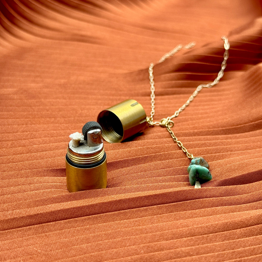 Brass lighter with turquoise stones on a gold necklace chain
