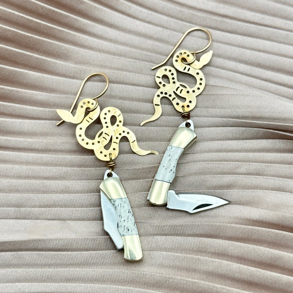 gold snake pendant with bone 
inlay mini pocketknife hanging from gold ear wire