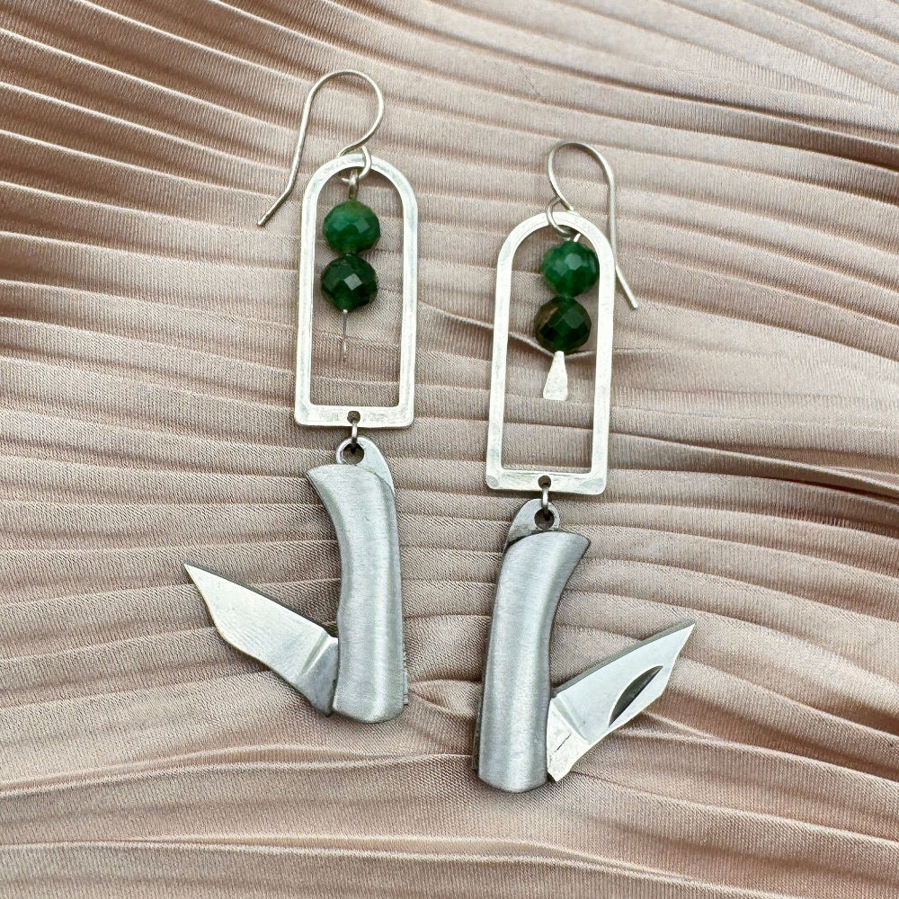 Silver Metal Billie Mini Pocket Knife dangling from rounded top frame with two faceted emerald beads hanging from ear wire