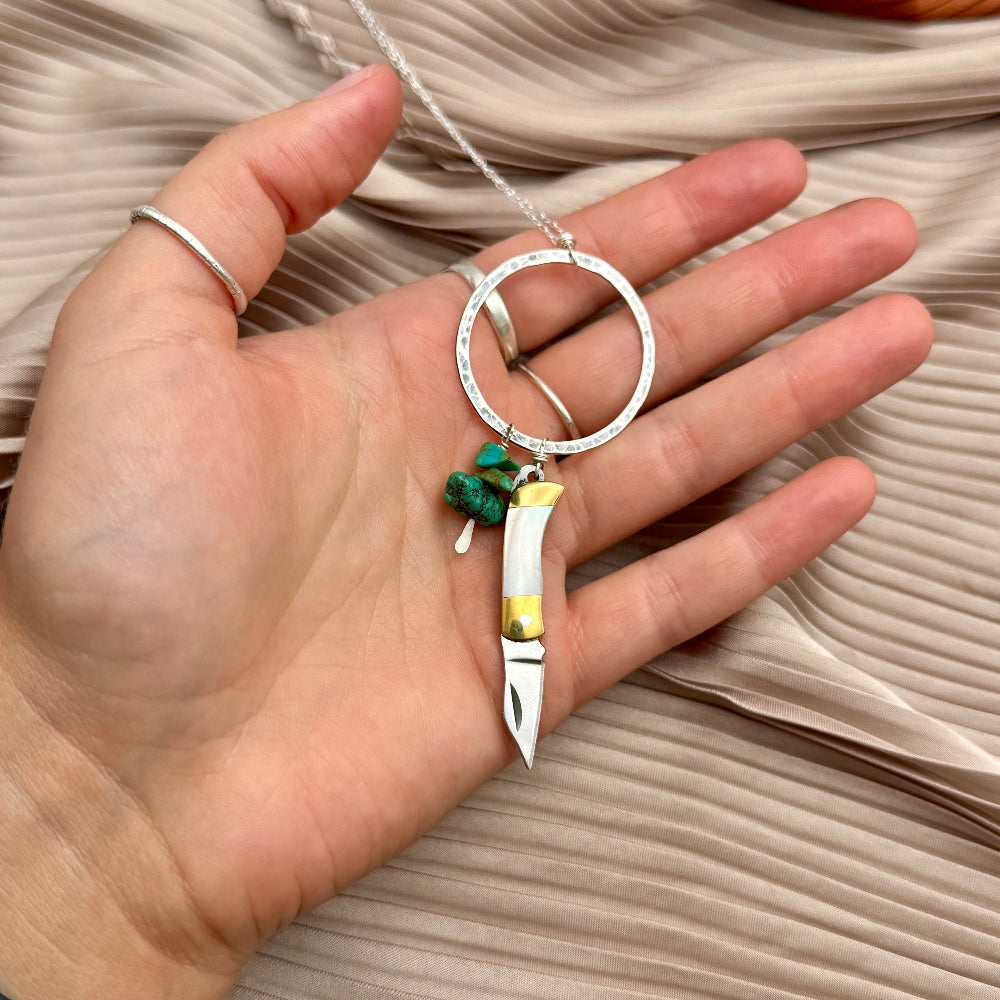 Necklace with small mother of pearl inlay pocketknife and two turquoise bead chips hanging from open circle pendant
