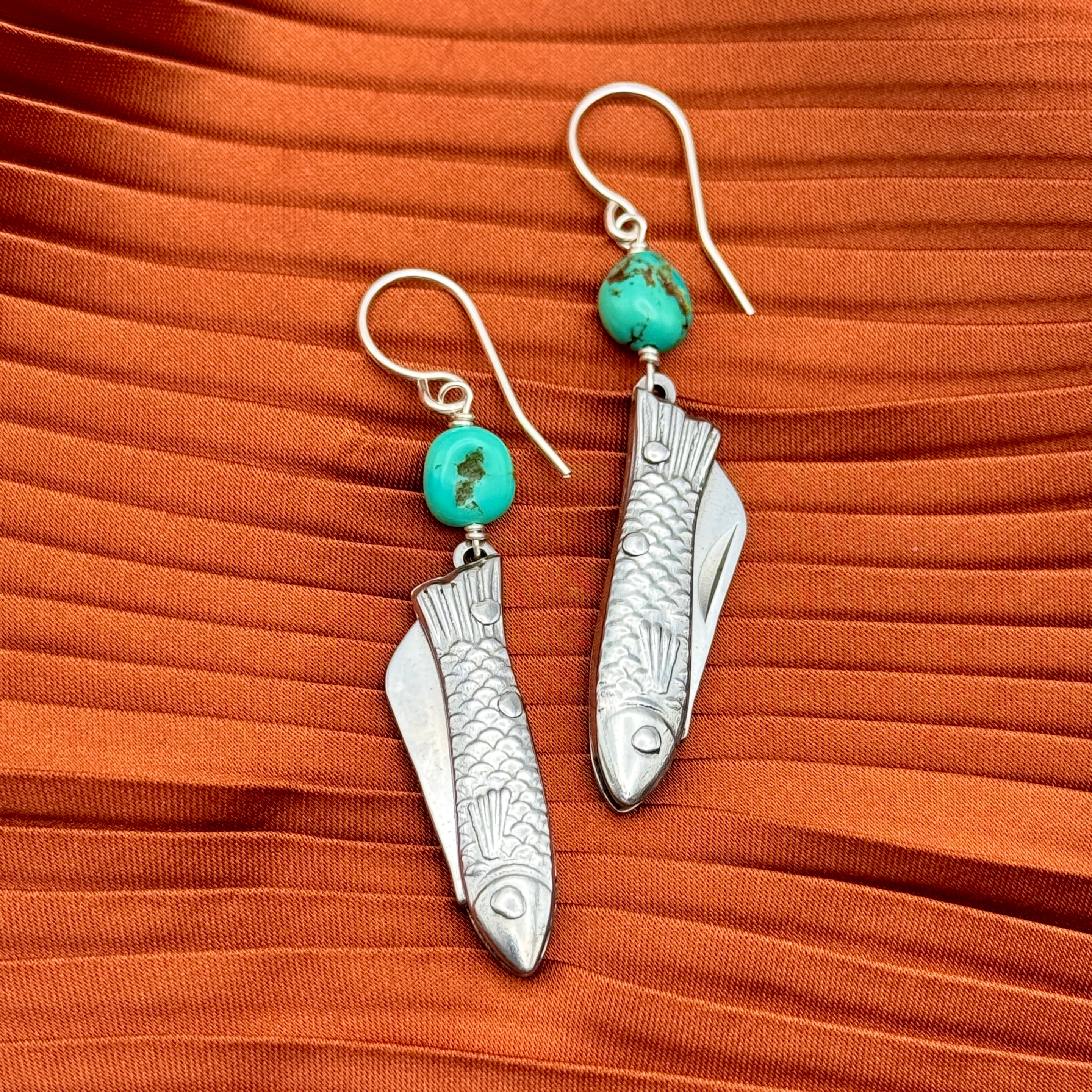A pair of earrings featuring silver miniature fish shaped utility working pocket knife with turquoise nuggets on a sterling silver or 14 karat gold fill ear wire