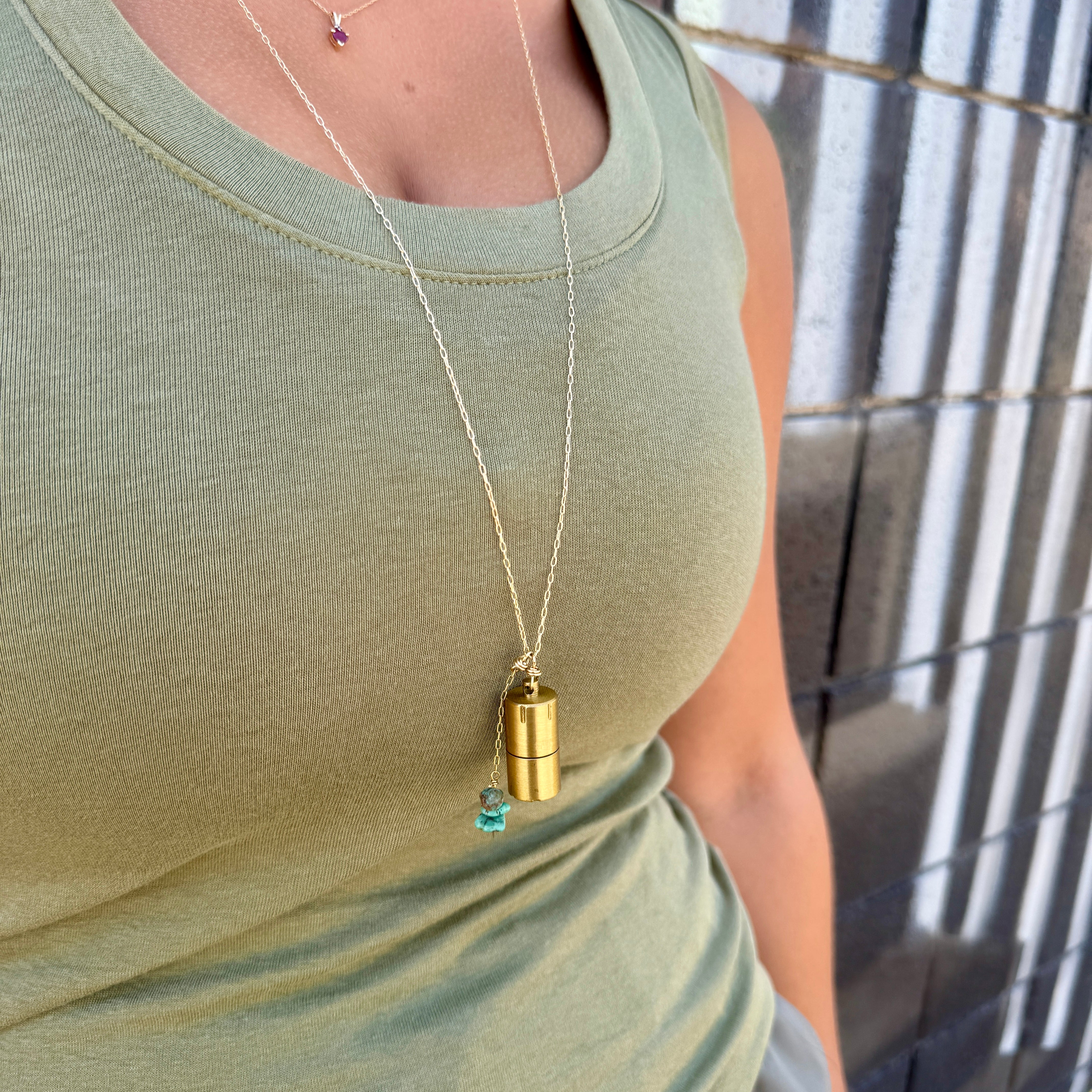 Brass lighter with turquoise stones on a gold necklace chain