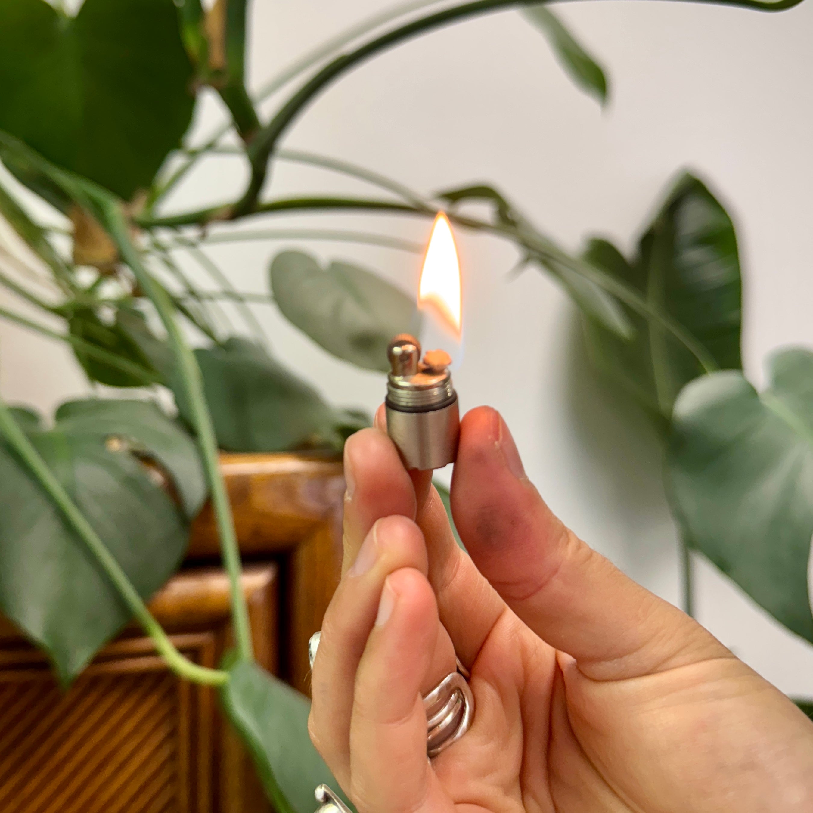 silver trixie lighter lit with flame