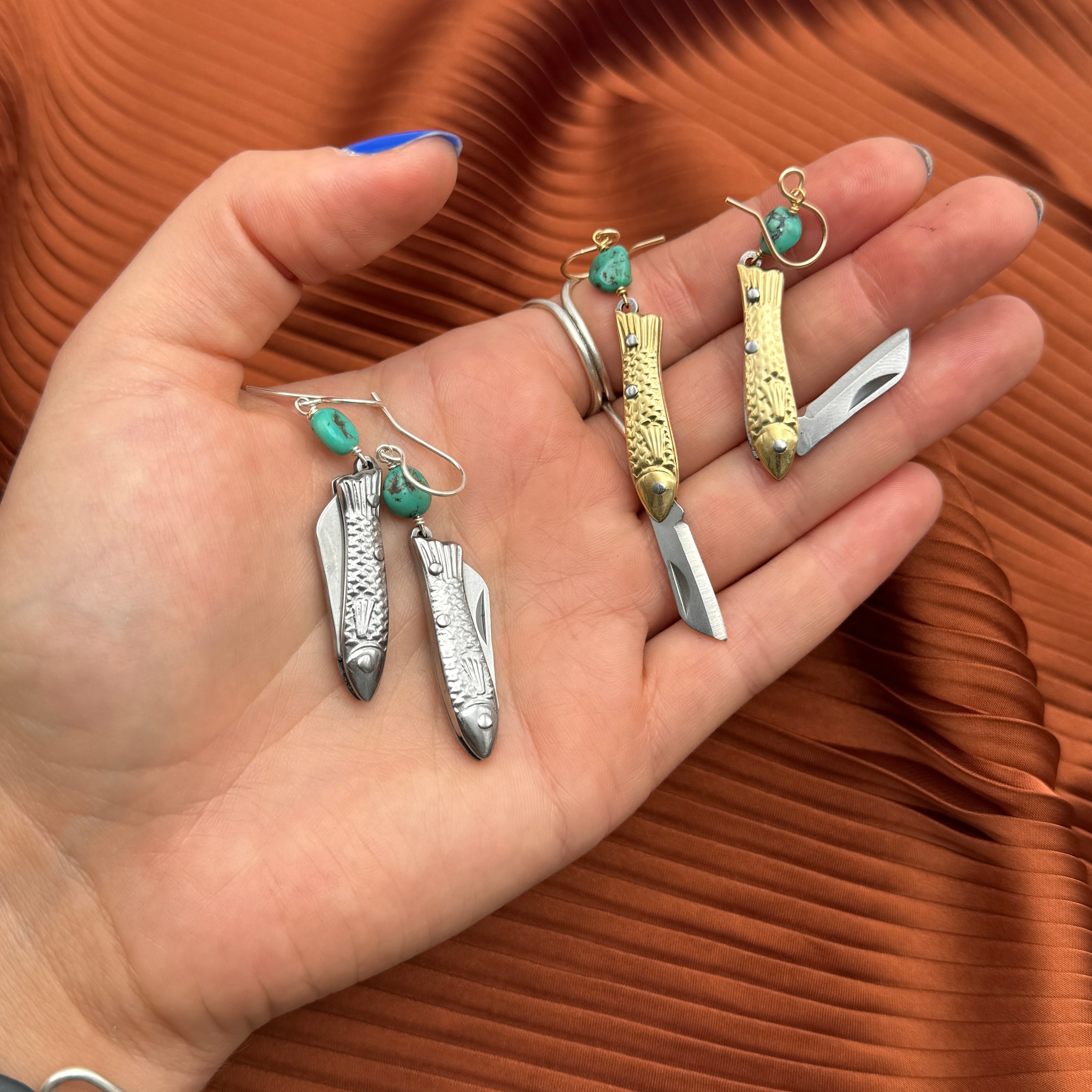 A pair of earrings featuring gold or silver miniature fish shaped utility working pocket knife with turquoise nuggets on a sterling silver or 14 karat gold fill ear wire