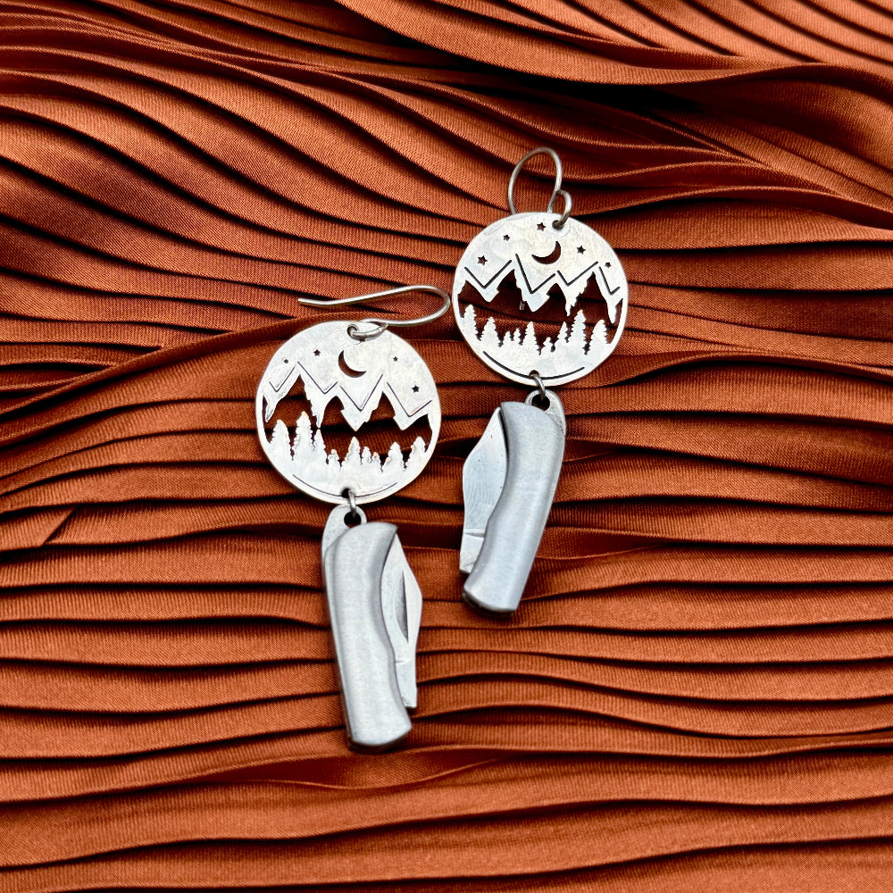 Mountain Night Moon Pine tree pendant hanging from ear wire with miniature billie gold or silver pocketknives