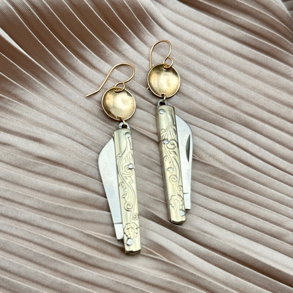 Etched Gold Handle Working PocketKnife hanging from ear wire with circle