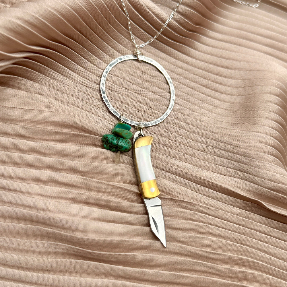 Necklace with small mother of pearl inlay pocketknife and two turquoise bead chips hanging from open circle pendant