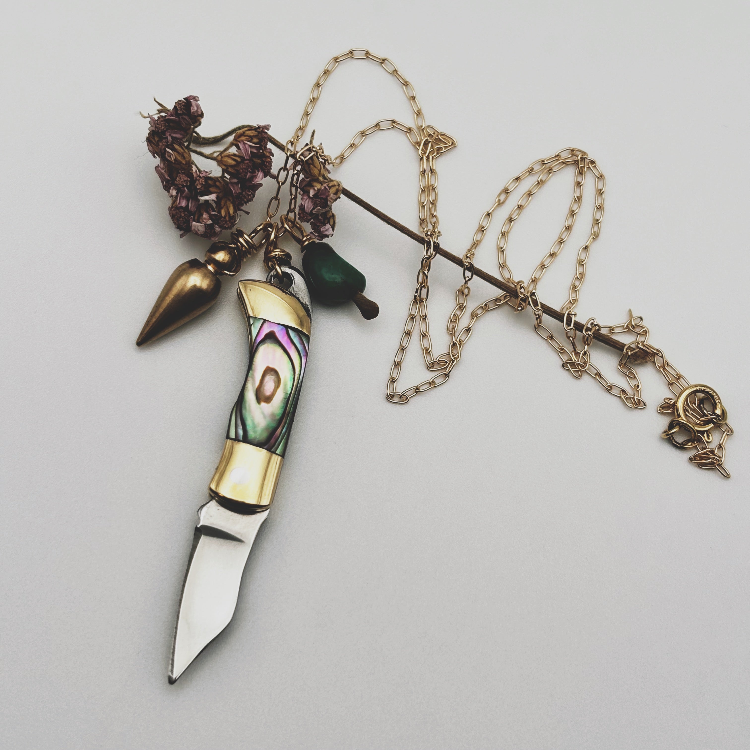 Abalone inlay and gold handle miniature pocketknife hanging with a turquoise stone and mini bullet