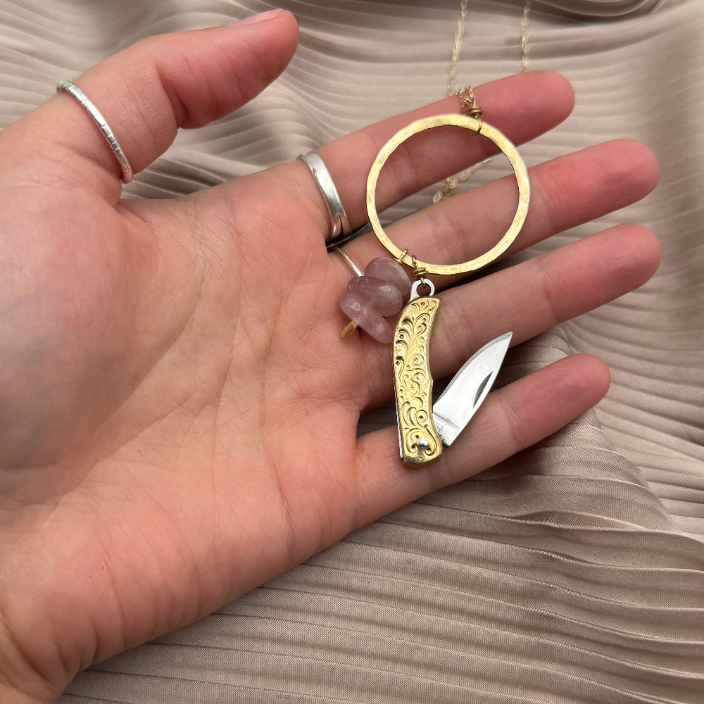 Necklace with small mother of pearl inlay pocketknife and two turquoise bead chips hanging from open circle pendant