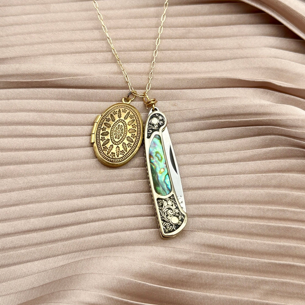 gold locket and a small ornate pocket knife with abalone inlay on chain, blending elegance and utility 