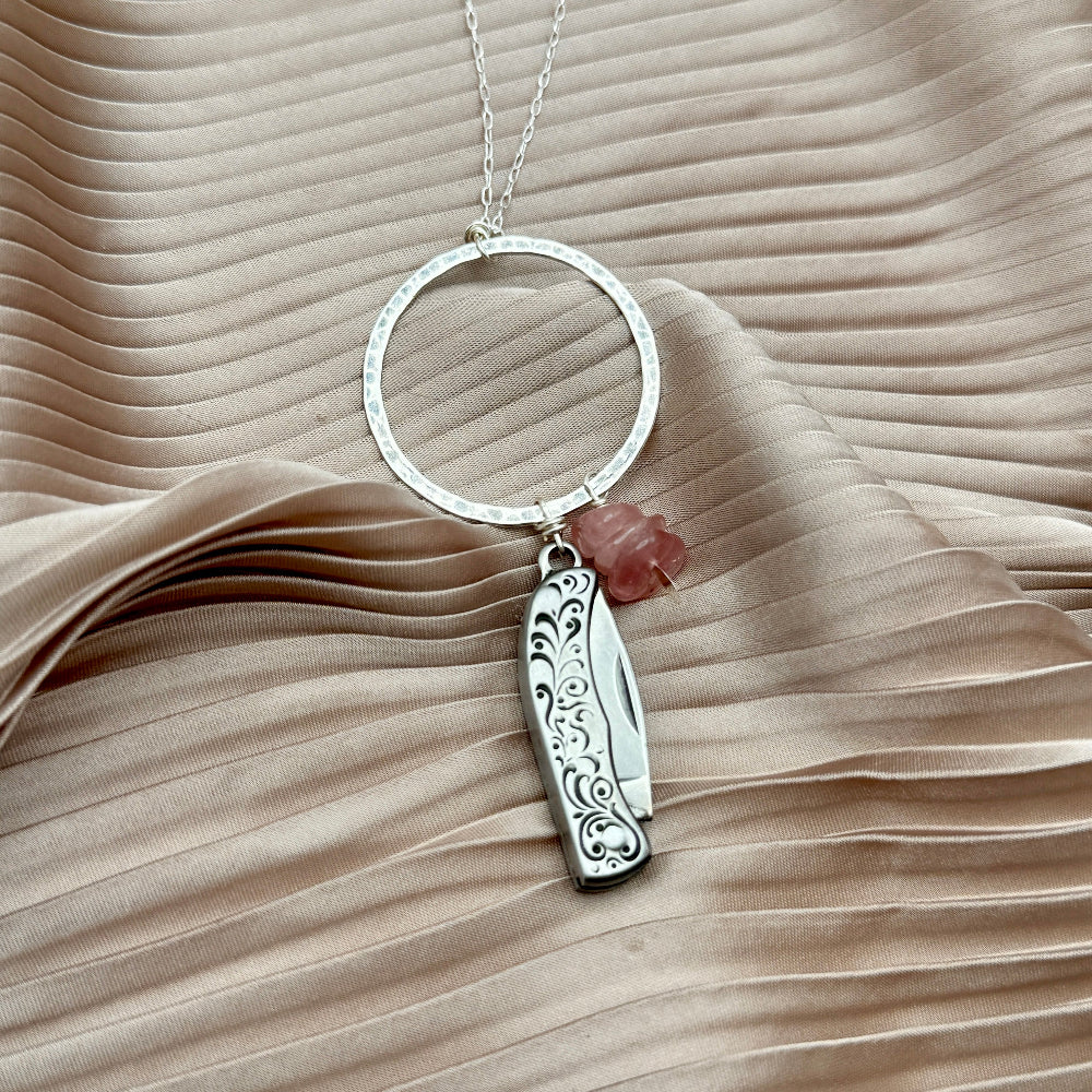 Necklace with small mother of pearl inlay pocketknife and two turquoise bead chips hanging from open circle pendant