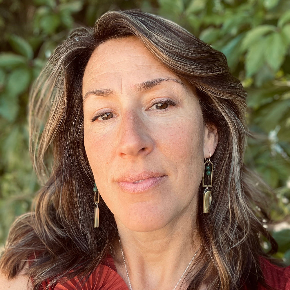 Gold Metal Billie Mini Pocket Knife dangling from rounded top frame with two faceted emerald beads hanging from ear wire