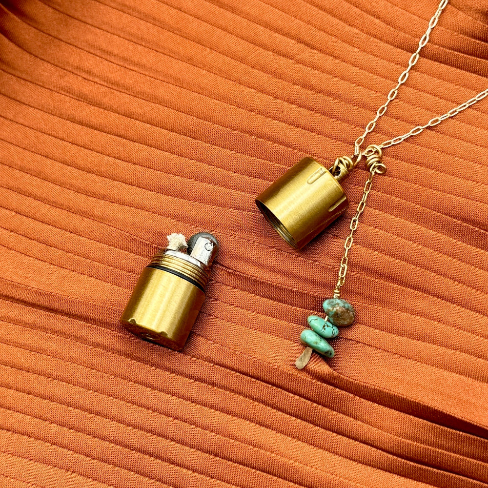 Brass lighter with turquoise stones on a gold necklace chain