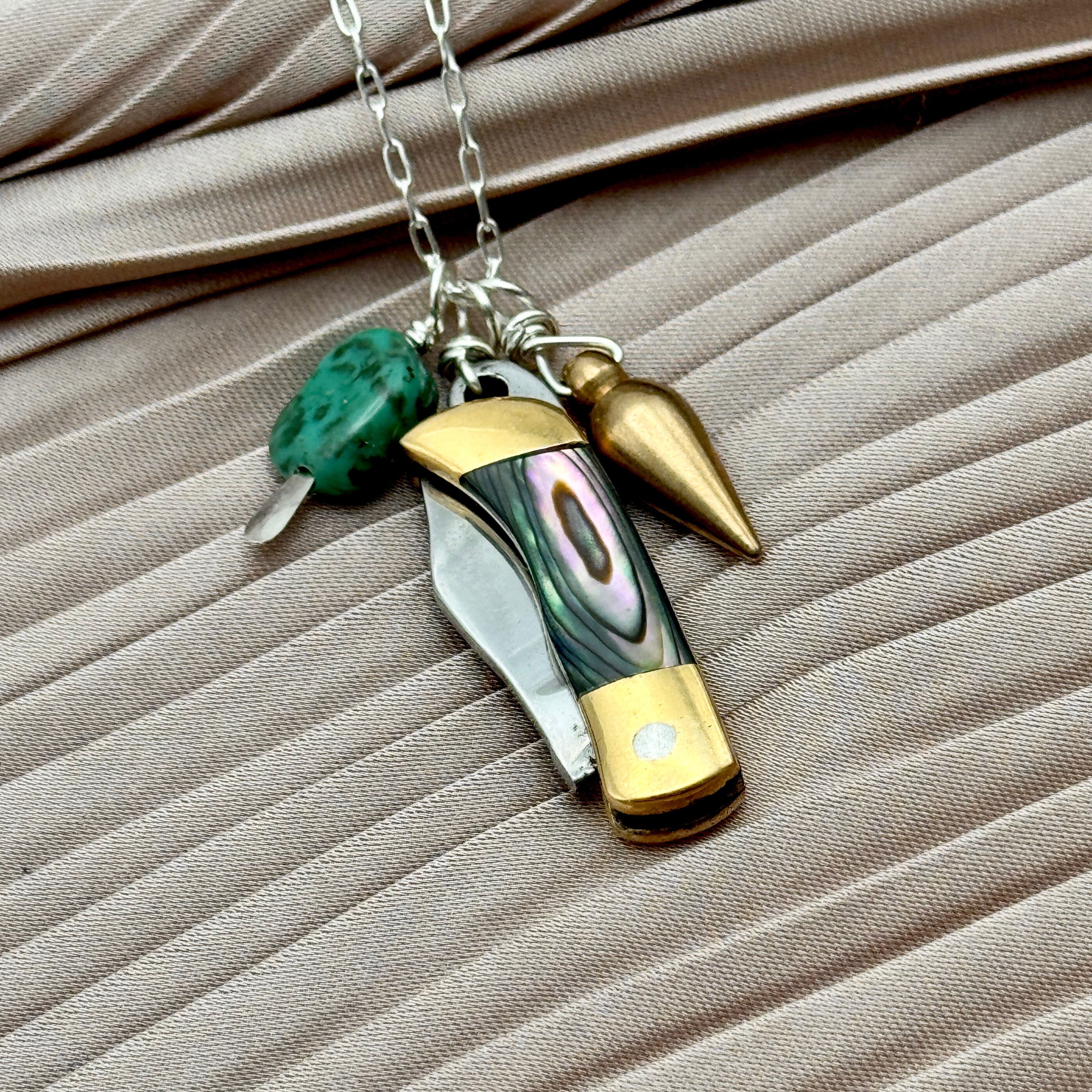 Abalone inlay and gold handle miniature pocketknife hanging with a turquoise stone and mini bullet
